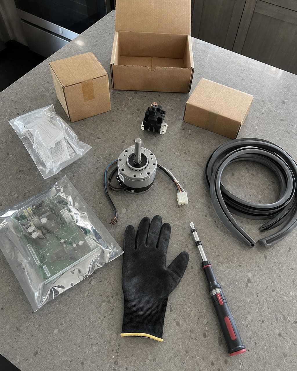Genuine OEM Sub-Zero parts laid out on a marble counter in a Walnut Creek kitchen